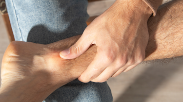 пацієнт тримається за стопу через оніміння як ілюстрація до матеріалу про консультацію при онімінні стопи у клініці Медонія Прайм