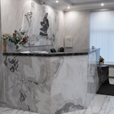 рецепція у клініці Медонія Прайм у Хмельницькому з мармуровою стійкою, логотипом на стіні та зоною очікування