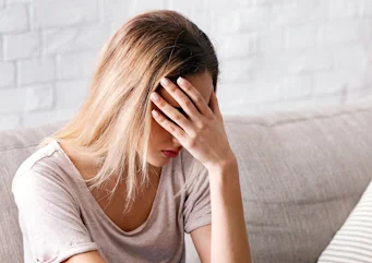 жінка тримається за голову через інтенсивний біль як ілюстрація до матеріалу про причини кластерного головного болю та порушення сну в клініці Медонія Прайм