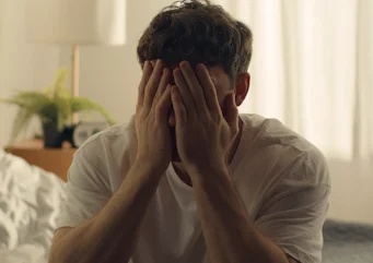 чоловік тримається за голову через інтенсивний біль як ілюстрація до матеріалу про стрес як можливий тригер кластерного головного болю в клініці Медонія Прайм