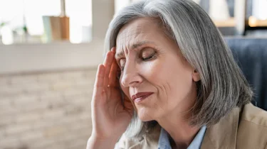 жінка з сильним болем у скронях як ілюстрація до матеріалу про інтенсивний біль у скронях при кластерному головному болю в клініці Медонія Прайм