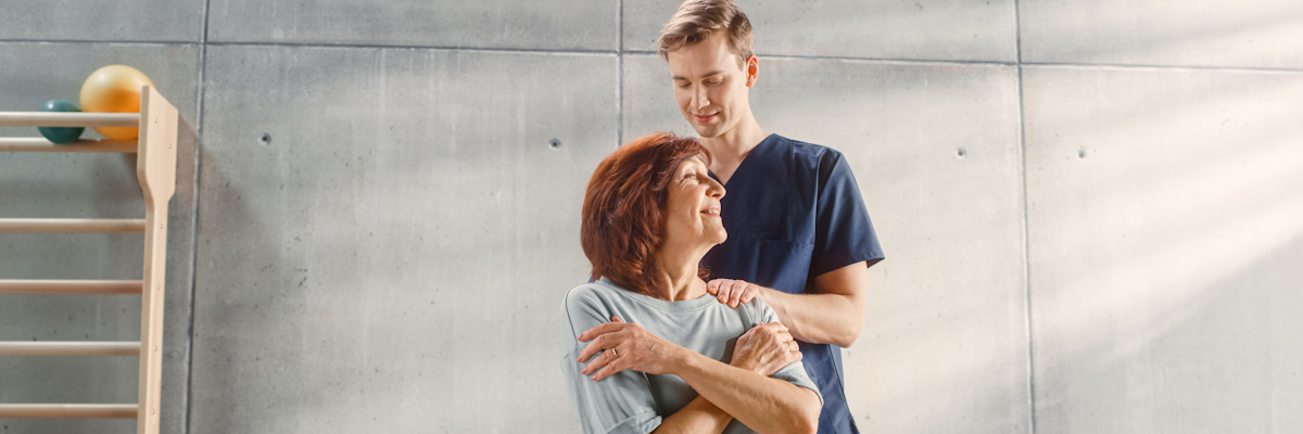 спеціаліст допомагає пацієнтці під час реабілітації як ілюстрація до матеріалу про лікування радикуліту методами фізичної реабілітації в клініці Медонія Прайм