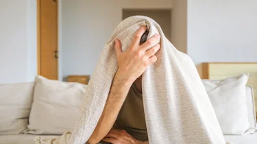 людина лежить із рушником на голові через напад мігрені як ілюстрація до сторінки про лікування мігрені у клініці Медонія Прайм у Хмельницькому