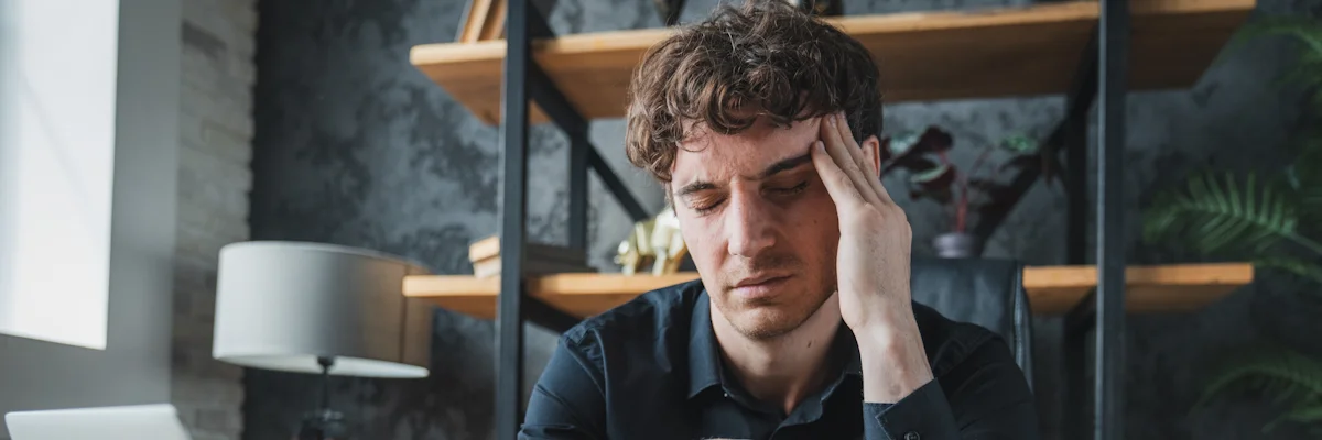 чоловік тримається за скроню через сильний головний біль як ілюстрація до матеріалу про кластерний головний біль у чоловіків в клініці Медонія Прайм