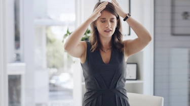 жінка тримається за голову через запаморочення і нудоту як ілюстрація до матеріалу про причини запаморочення у клініці Медонія Прайм