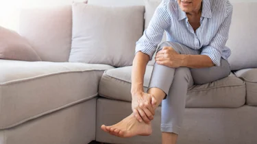 людина старшого віку тримається за ногу через біль і спазм уночі як ілюстрація до матеріалу про біль і спазм у нозі в літніх людей в клініці Медонія Прайм