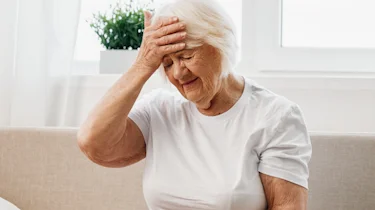 старша жінка тримається за лоб як ілюстрація до матеріалу про відновлення після геморагічного інсульту у клініці Медонія Прайм