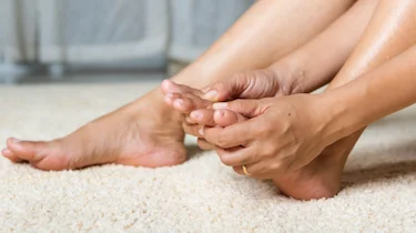 руки масажують пальці стопи як ілюстрація до матеріалу про біль у пальцях стопи при хронічній ішемії нижніх кінцівок в клініці Медонія Прайм
