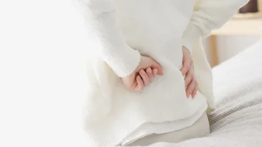 крупний план рук на попереку як ілюстрація до матеріалу про лікування хронічного болю в попереку у клініці Медонія Прайм