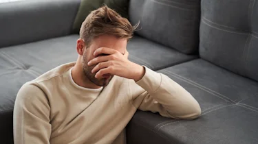 чоловік натискає пальцями на скроні через сильний біль у голові як ілюстрація до матеріалу про консультацію при болю в скронях в клініці Медонія Прайм