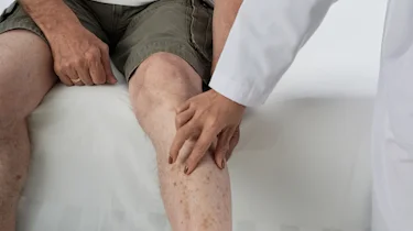 спеціаліст оглядає ногу літньої людини як ілюстрація до матеріалу про діагностику причин судом ніг у літніх людей в клініці Медонія Прайм