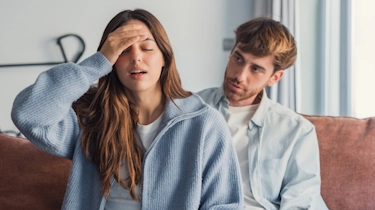 жінка з головним болем і чоловік поруч як ілюстрація до матеріалу про індивідуальний підхід до лікування головного болю в клініці Медонія Прайм