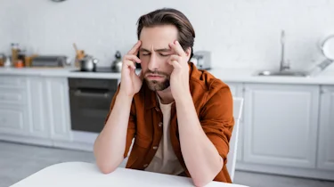 чоловік закриває обличчя рукою через різкий головний біль як ілюстрація до матеріалу про допомогу при сильному головному болю в клініці Медонія Прайм