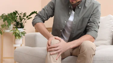 людина тримається за ногу через біль і спазм як ілюстрація до матеріалу про діагностику болю і спазму в нозі в клініці Медонія Прайм