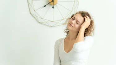 молода жінка тримається за голову через біль як ілюстрація до сторінки що робити якщо болить голова у клініці Медонія Прайм у Хмельницько