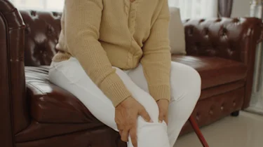 людина тримається за коліно як ілюстрація до матеріалу про біль у коліні та хронічну ішемію нижніх кінцівок в клініці Медонія Прайм